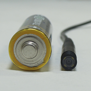 SNK-42 SNK-42のカメラヘッドと単3乾電池の比較写真（前面）